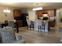 Open concept kitchen with dark wood cabinets, island with seating, and an adjacent dining area at 441 Squires Grove Dr, Winter Haven, FL 33880