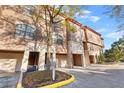 Townhome featuring a stucco facade, private garages, and manicured landscaping at 6109 Metrowest Blvd # 105, Orlando, FL 32835