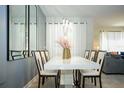 Bright dining room with white table and modern light fixture at 750 Pebble Beach Dr, Davenport, FL 33896