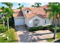 Aerial view of a charming home boasting a tile roof, paved driveway, and lush landscaping at 802 Brunello Dr, Davenport, FL 33897