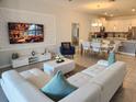 Open-concept living room showcases stylish decor, seamlessly flowing into the dining area and kitchen at 8885 Cabot Cliffs Dr # 103, Davenport, FL 33896