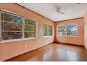 Well-lit living room featuring multiple windows and original hardwood floors at 900 Delaware Ave, St Cloud, FL 34769