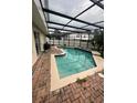 Screened-in pool area featuring a pool with brick pavers at 920 Gillingham Ct, Kissimmee, FL 34758