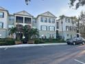 Exterior view of a condo building featuring manicured landscaping, benches, and reserved parking at 11446 Jasper Kay Ter # 106, Windermere, FL 34786