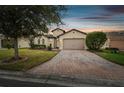 Charming single-Gathering home featuring brick driveway, attached two-car garage, and freshly manicured landscaping at 1398 Del Mar Dr, Kissimmee, FL 34759