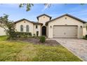 Single-Gathering home featuring brick driveway, two-car garage, arched windows and manicured front yard at 1398 Del Mar Dr, Kissimmee, FL 34759