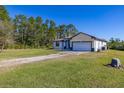 A single-story home with stone accents, a two-car garage, and a spacious yard sits among lush trees at 1741 Eldorado Ct, St Cloud, FL 34771
