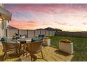 Serene backyard patio with comfortable seating and a picturesque sunset view perfect for outdoor relaxation at 1755 Buckeye Rd, Davenport, FL 33837