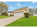 Home showcasing a two-car garage and an inviting driveway lined with green grass at 238 N Hampton Dr, Davenport, FL 33897
