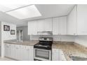 Bright kitchen featuring granite countertops, white cabinets, and modern stainless steel appliances at 2424 Barley Club Ct # 8, Orlando, FL 32837
