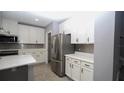Modern kitchen boasts stainless steel refrigerator and ample white cabinetry at 3199 Turret Dr, Kissimmee, FL 34743