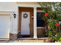 Inviting front entrance with a decorative wreath and flowering hibiscus bush at 3491 Allegra Cir, St Cloud, FL 34772