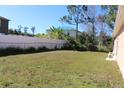 Large backyard enclosed by a white fence and chain link fence at 350 Chelmsford Ct, Kissimmee, FL 34758