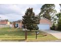 Quaint single-Gathering home showcasing a lush lawn, a mature tree, and a convenient two-car garage at 350 Chelmsford Ct, Kissimmee, FL 34758