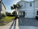 Charming townhome featuring well-manicured lawn, beautiful stone driveway and a cozy front porch seating area at 4740 Tribute Trl, Kissimmee, FL 34746