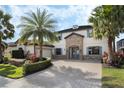 Gorgeous two-story home with stone accents, paver driveway, and meticulously landscaped yard at 4959 Tennessee Lake Dr, Auburndale, FL 33823
