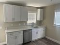 Bright kitchen featuring white cabinets, stainless steel appliances, and quartz countertops, offering a sleek and modern design at 521 Tennessee Ave, St Cloud, FL 34769