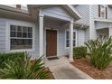 Close-up of the front porch with a brown entry door and neat landscaping at 5360 Diplomat Ct # 107, Kissimmee, FL 34746