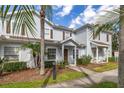 A townhouse boasts mature landscaping, a palm tree, and a welcoming front entrance at 5360 Diplomat Ct # 107, Kissimmee, FL 34746