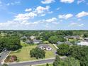 Scenic aerial shot of a home on a large lot, surrounded by lush greenery and neighborhood homes at 5701 Crestview Dr, Lady Lake, FL 32159