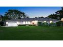 Charming single-story home with a manicured lawn and an attached two-car garage at dusk at 6845 Old Melbourne Hwy, St Cloud, FL 34771
