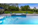 Sparkling swimming pool with an attached hot tub and a spacious green lawn beyond at 6845 Old Melbourne Hwy, St Cloud, FL 34771