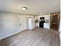 Open-concept kitchen with white appliances, cabinets, and modern vinyl flooring throughout the home at 708 Se Pine Ave, Fort Meade, FL 33841