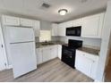 Kitchen featuring white cabinets, granite countertops, and black appliances at 708 Se Pine Ave, Fort Meade, FL 33841