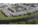 Aerial view of community with parking, landscaping, and a tranquil pond at 777 W Lancaster Rd # A-13, Orlando, FL 32809
