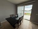 Dining area with table, seating four, and sliding glass doors that lead to the back yard at 8835 Conway Rd, Polk City, FL 33868