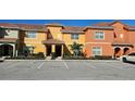 Charming townhome exterior featuring colorful paint, tile roof, and assigned parking spaces at 8961 California Palm Rd, Kissimmee, FL 34747