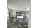 Open-concept kitchen featuring gray cabinets, stainless steel appliances, a center island, and modern pendant lighting at 915 Alsace Dr, Kissimmee, FL 34759