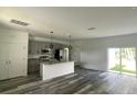 Bright kitchen with gray cabinets, stainless steel appliances, granite countertops, and sliding glass doors to the backyard at 915 Alsace Dr, Kissimmee, FL 34759
