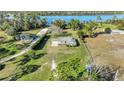 An aerial shot of the house highlighting its proximity to a lake and expansive lawn at 6845 Old Melbourne Hwy, St Cloud, FL 34771