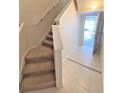 Carpeted stairway leading up to the next level with natural light and neutral decor at 1001 Via Santae Ln # 201, Celebration, FL 34747