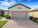 Spacious two-car garage with a brick-paved driveway, complementing the home's exterior design at 1036 Salamanca Pl, Davenport, FL 33837