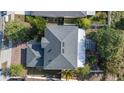 Birds eye view of the house featuring a gray roof, skylights, and mature landscaping on a sunny day at 1067 Ronlin St, Haines City, FL 33844