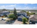 Aerial view of a two-story blue home with a gray roof, lush greenery, and a tranquil waterfront view at 1067 Ronlin St, Haines City, FL 33844