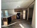 View of a modern kitchen with black appliances, wooden cabinetry, and durable wood-look floors at 11776 Nw 18Th Pl, Ocala, FL 34482