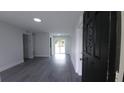 Bright, open-concept living room with new gray flooring and sliding doors to the backyard at 2411 Nansen Ave, Orlando, FL 32817