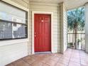 Inviting front door with tile entryway, a red door with sidelight and a view of a palm tree at 3004 Parkway Blvd # 202, Kissimmee, FL 34747