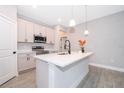 Modern kitchen with stainless steel appliances, island, pendant lighting, and stylish tile flooring at 3177 Sw 127Th Street, Ocala, FL 34473