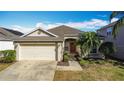 Inviting single-Gathering home featuring a two-car garage, manicured shrubs, and a warm, welcoming entrance at 331 Henley Cir, Davenport, FL 33896