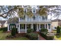 Charming two-story home featuring a welcoming front porch, lush landscaping, and classic architectural details at 614 Golfpark Dr, Celebration, FL 34747