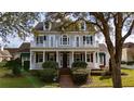 Stunning two-story traditional home boasts a charming front porch, balconies, and manicured landscaping at 614 Golfpark Dr, Celebration, FL 34747