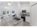 Modern kitchen with granite countertops, stainless steel appliances, breakfast bar, and white cabinetry at 6495 Eve St, St Cloud, FL 34771