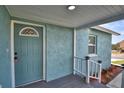 Inviting front entry with a decorative door and gray porch, surrounded by manicured landscaping at 713 Greenleaf Ln, Lake Wales, FL 33853