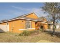 A charming single-story home featuring yellow siding, a front-facing garage, and mature landscaping at 714 Franklin Ct, Haines City, FL 33844