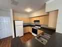 Well-lit kitchen featuring light wood cabinets and black countertops at 727 Siena Palm Dr, Celebration, FL 34747