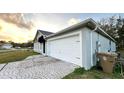 Shows a home's two car garage, light-colored siding and patterned brick driveway at 856 Jarnac Dr, Kissimmee, FL 34759